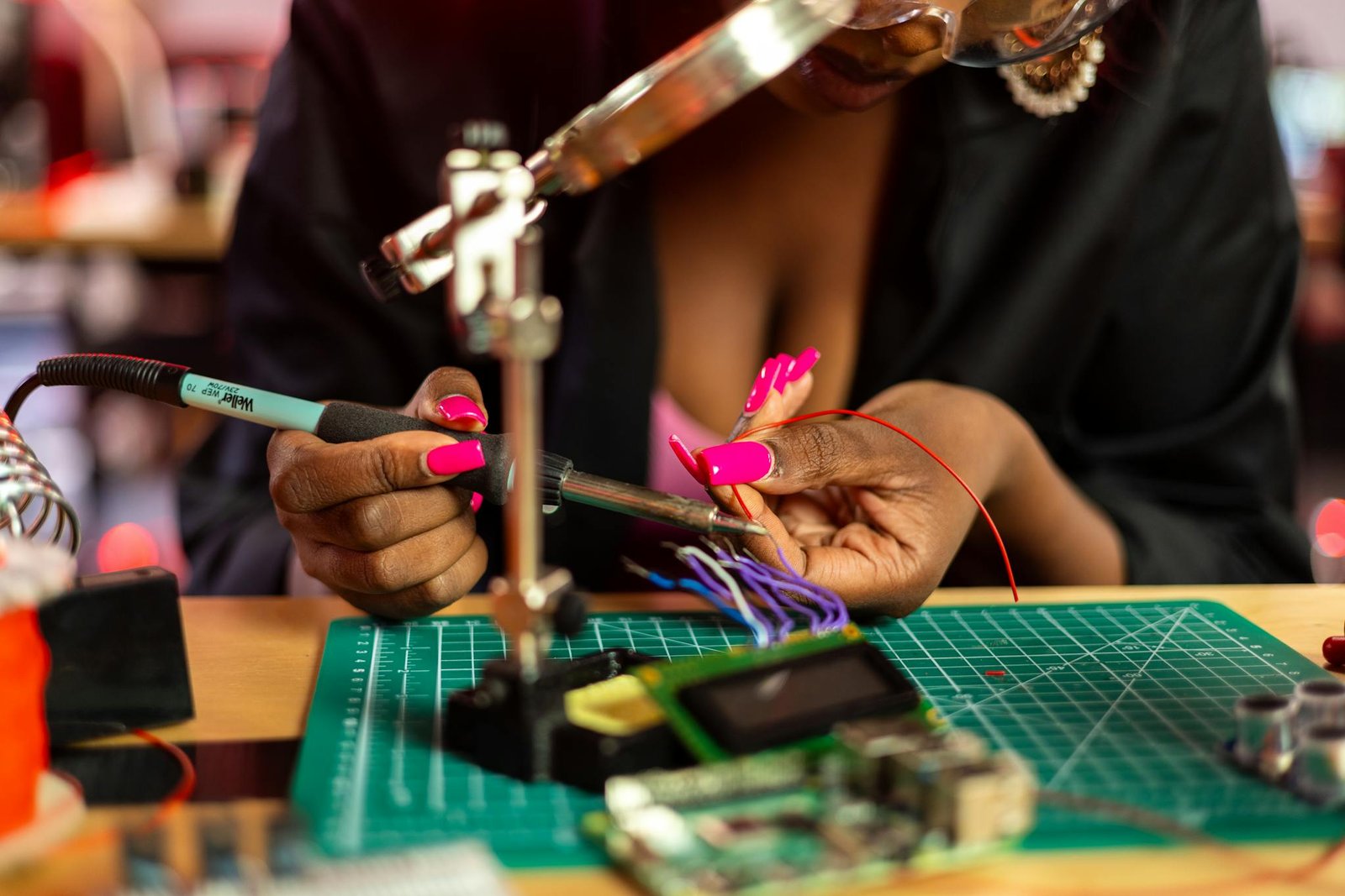 A woman skillfully soldering a circuit board, showcasing technical expertise and electronics work.